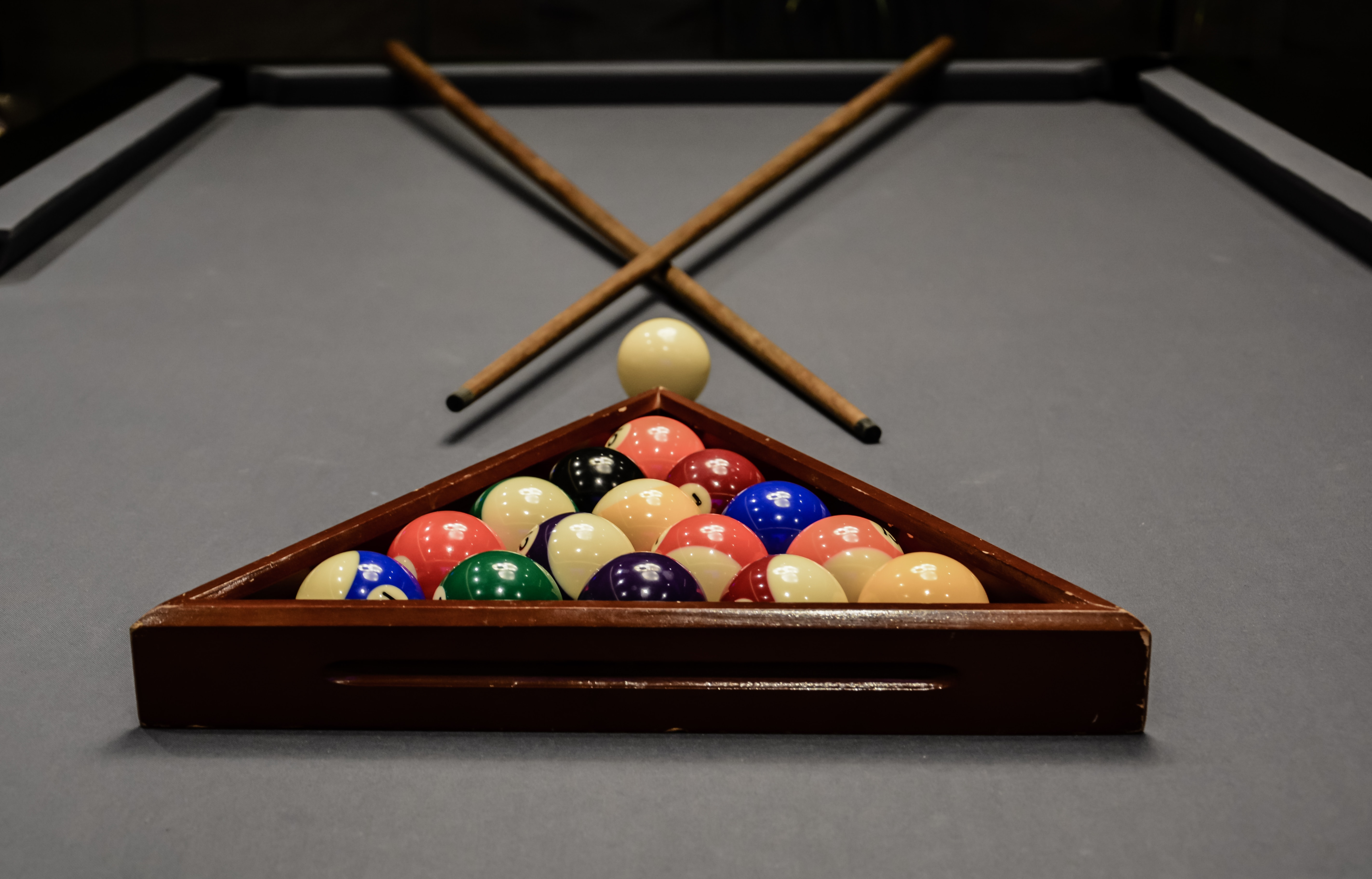Racked pool balls and cues on a billiard table