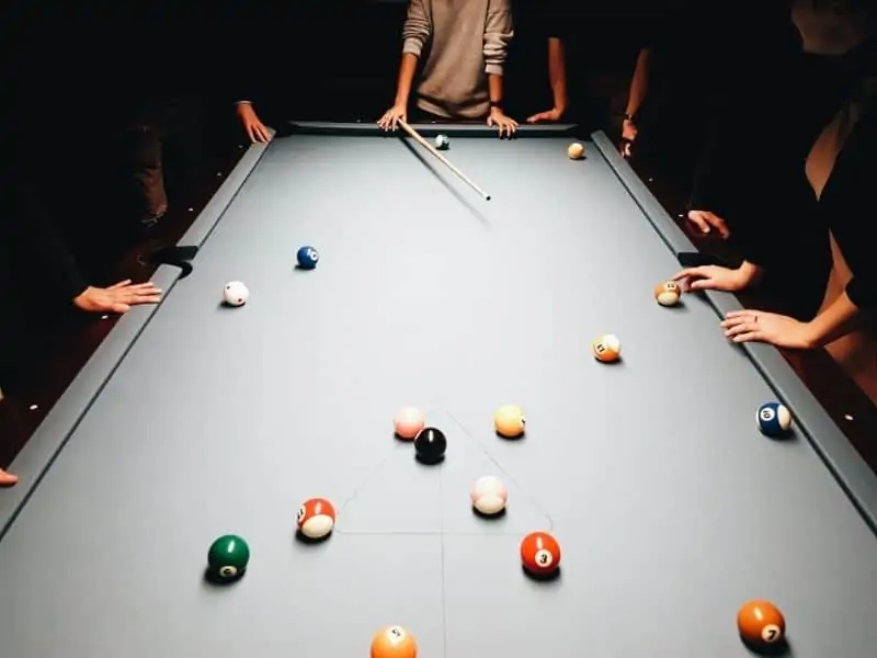 Guys gathered around a pool table Guys gathered around a pool table
