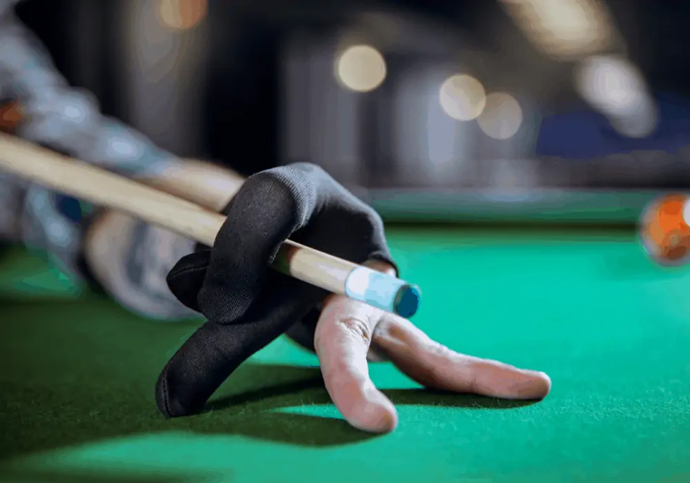 Close-up of a gloved hand holding a low-deflection pool cue